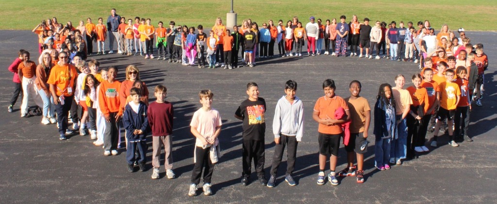 students and staff take pictures outside in orange shirts to show support for Unity Day