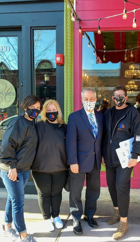 group of adults wearing masks in front of ice cream shop
