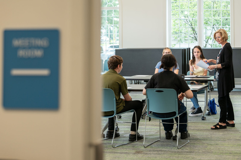 students at table with intern coordinator