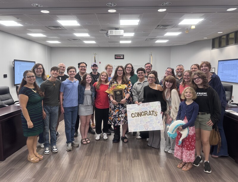 Karen Blair stands with family and friends in the board room at the District Office