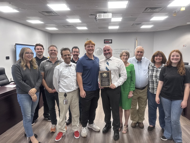 Ryan Schlott with family and friends in board room at district office