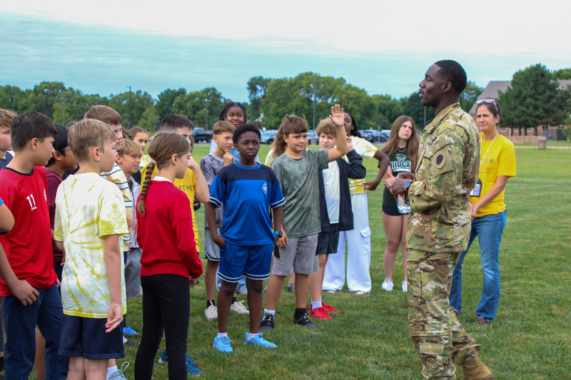 man in miiliary uniform talks to students