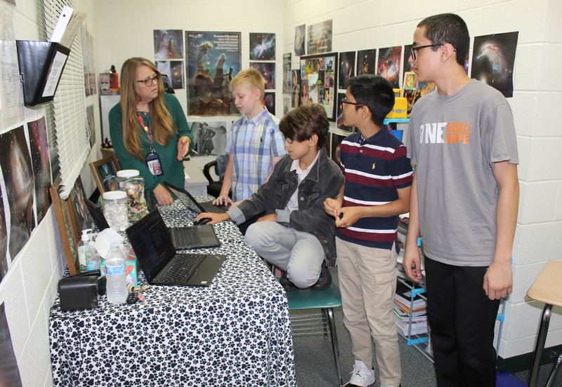 HGMS teacher and students discussing coding challenge