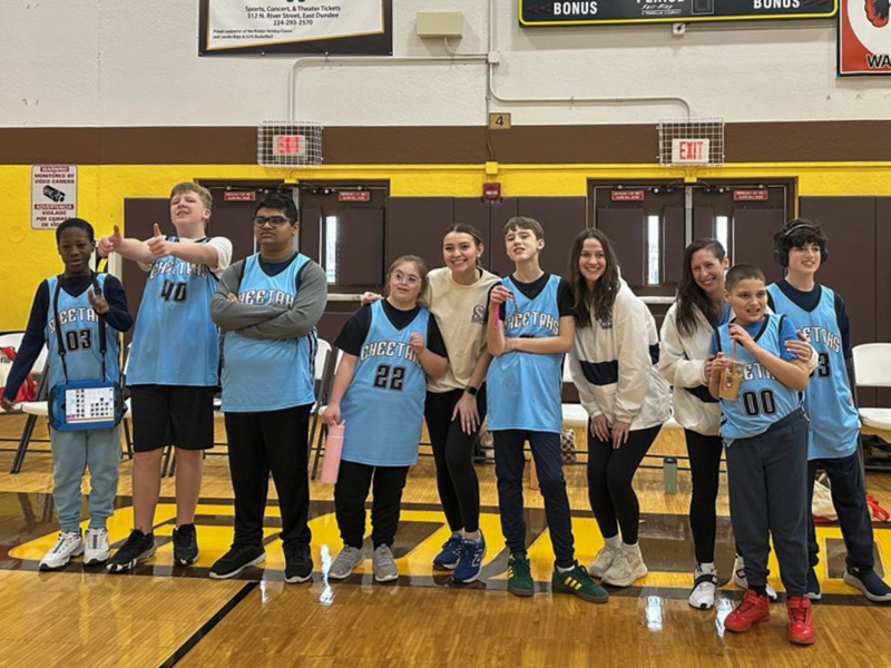 group of Special Olympic basketball players stand on court