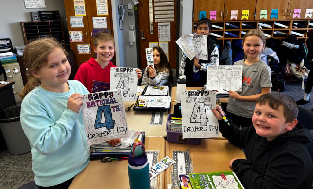 4th graders posing with fourth grade day packets