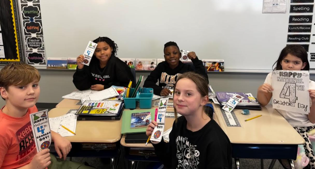 4th graders posing with fourth grade day packets