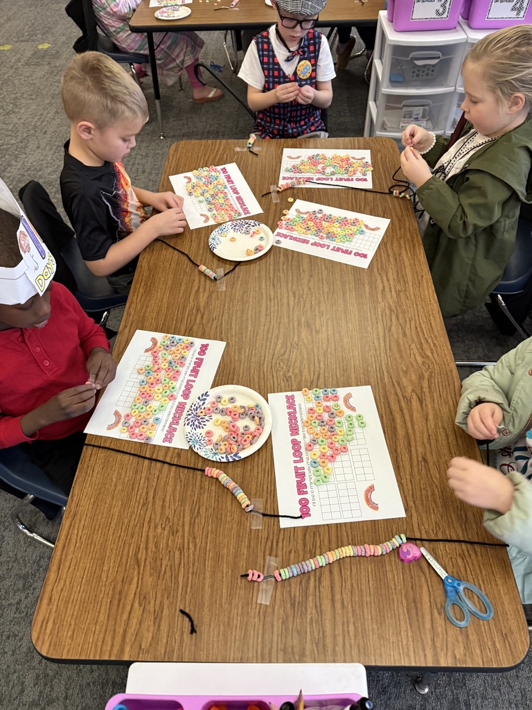 kindergarten  students counting 100 pieces of cereal for 100 day