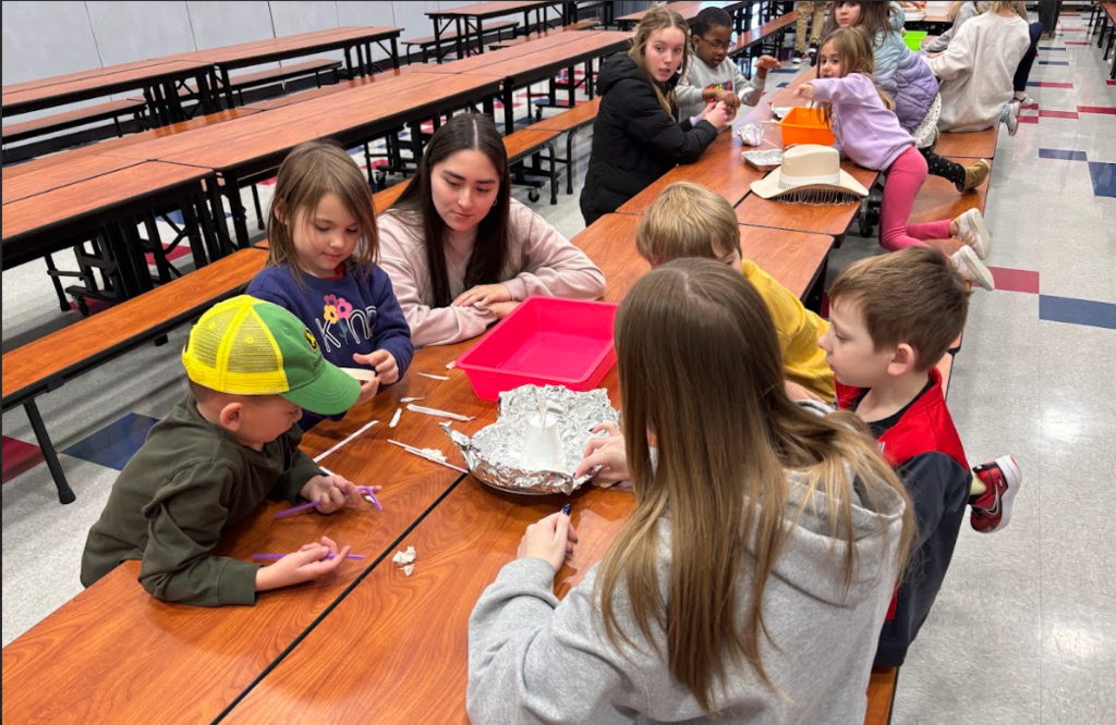 High school HOSA students helping kindergarteners build a boat
