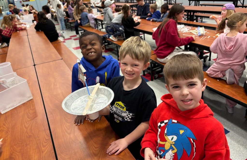 High school HOSA students helping kindergarteners build a boat
