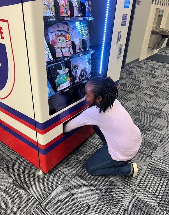 Student getting book from the vending machine