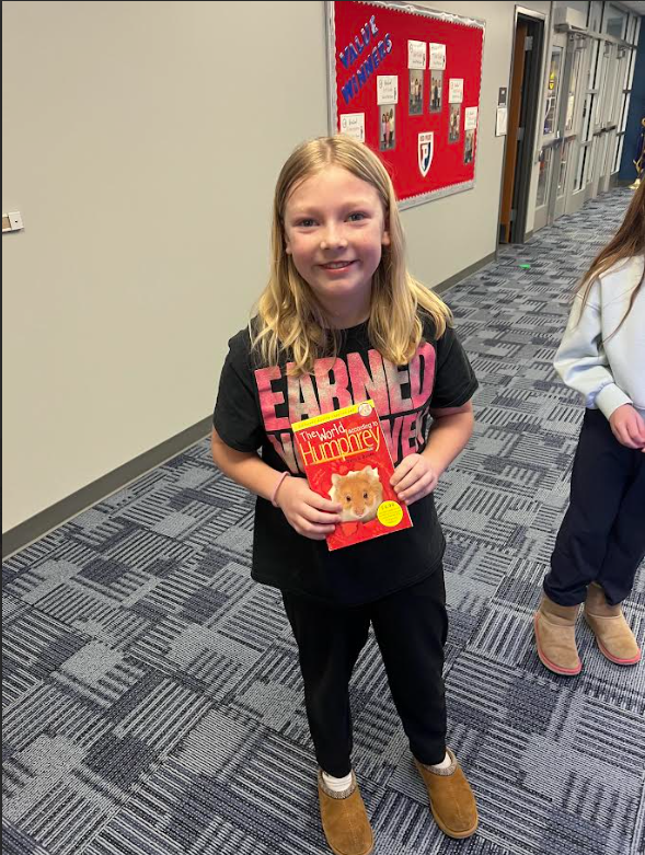 Student posing with book from vending machine