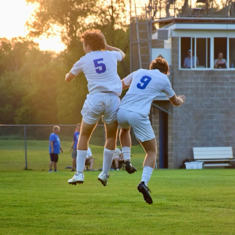 picture of two men’s soccer players jumping in excitement during game