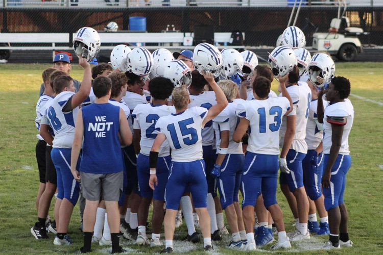picture of jv football team in a huddle 