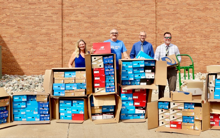picture of PCS staff with shoes that were donated to PCs