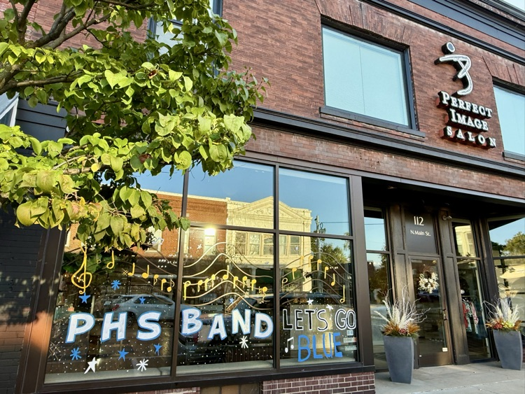 picture of downtown business with windows painted celebrating homecoming week 