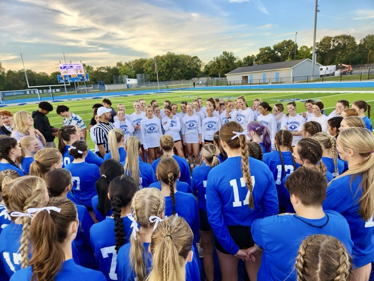 picture of powderpuff teams in a huddle 