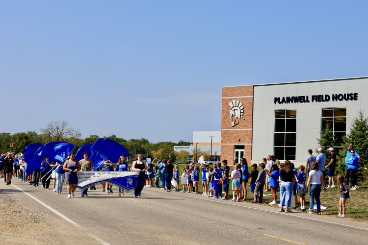 picture of students marching in and watching the homecoming parade 