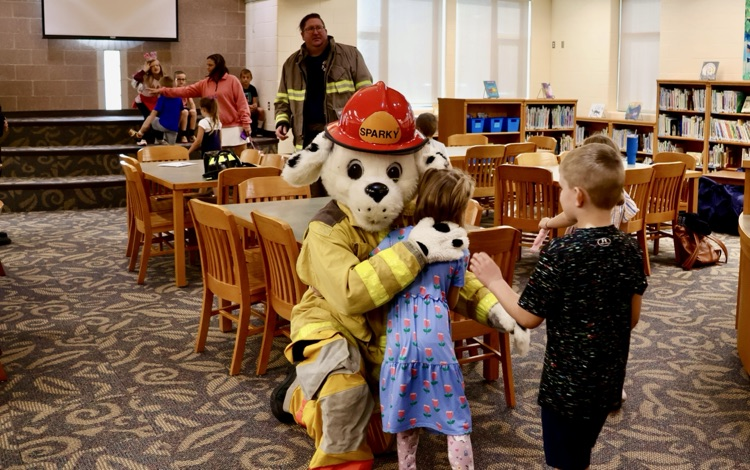 picture of cooper township fire department mascot hugging a student