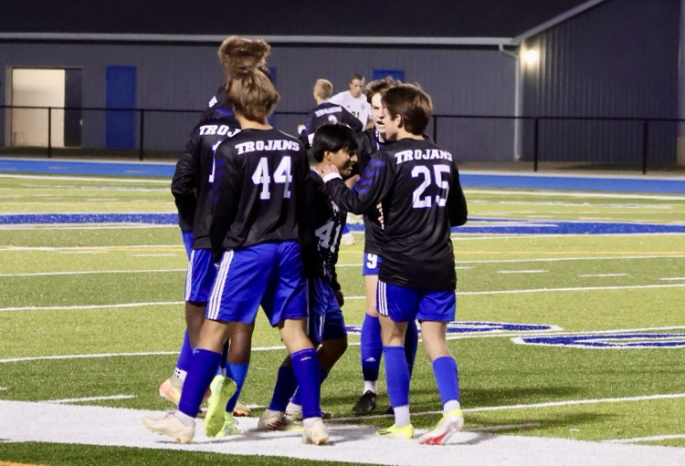 picture of varsity soccer team celebrating a goal 