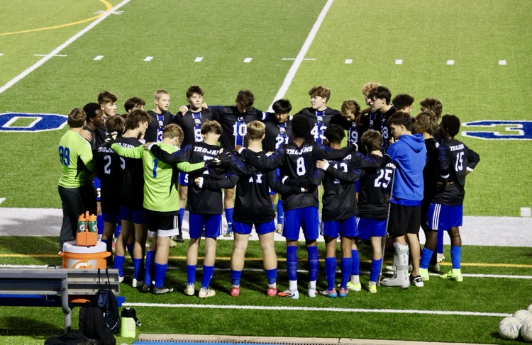 picture of varsity soccer team in a huddle