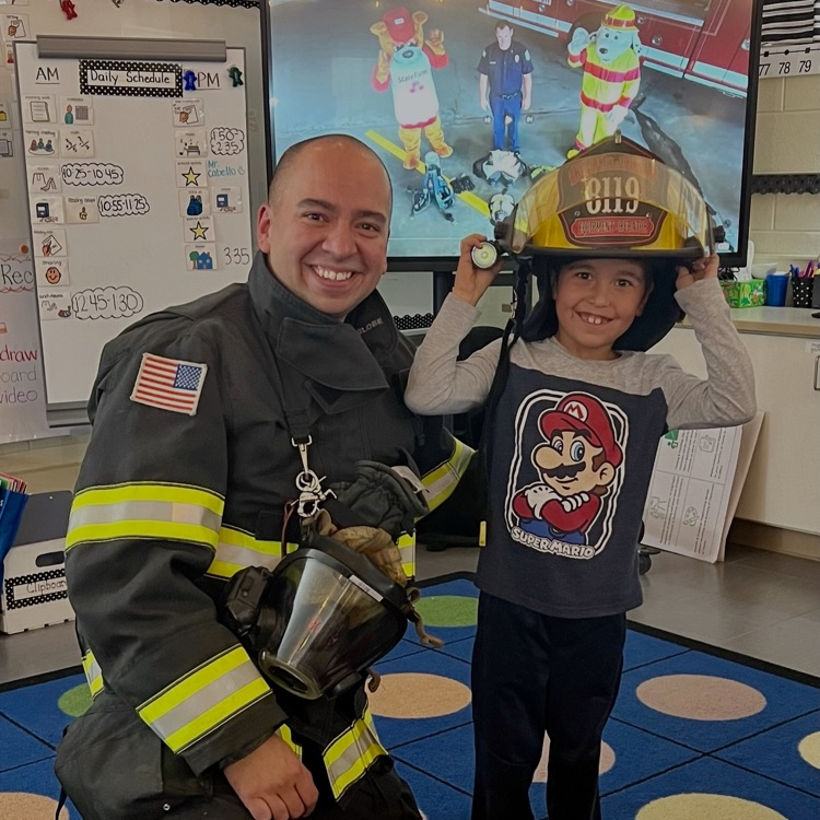 picture of student with a firefighter during a presentation