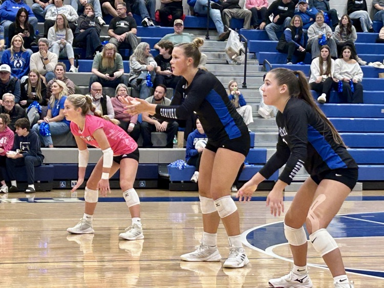 picture of three volleyball teammates during a game 