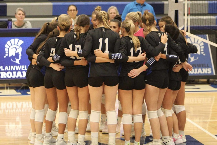picture of varsity volleyball team in a huddle 