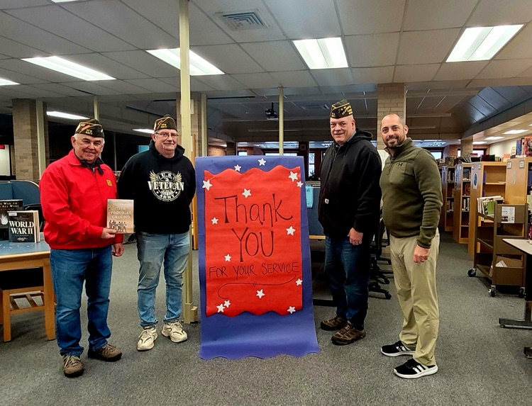 picture of assistant principal with three veterans at the phs library