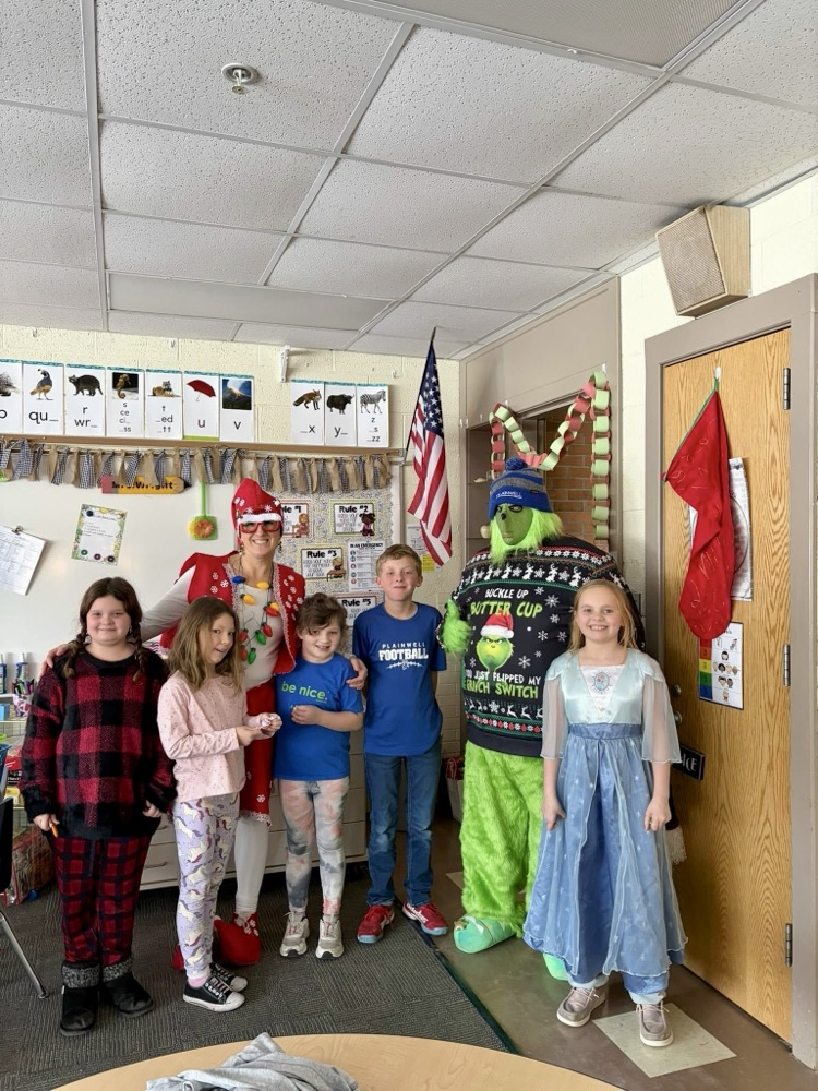 picture of a group of Starr students with “lucky the elf” and “the grinch"