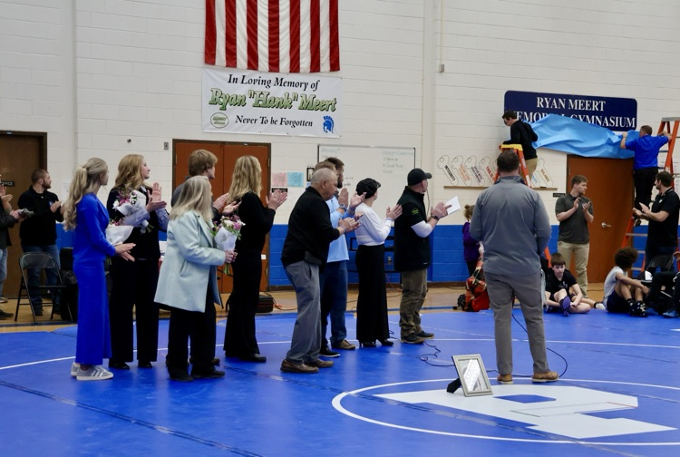 picture from unveiling of new sign at plainwell middle school, dedicating the gymnasium as the “Ryan Meert memorial gymnasium”