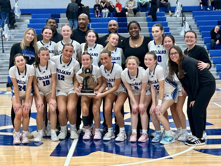 team picture of girls basketball team with the district championship trophy 