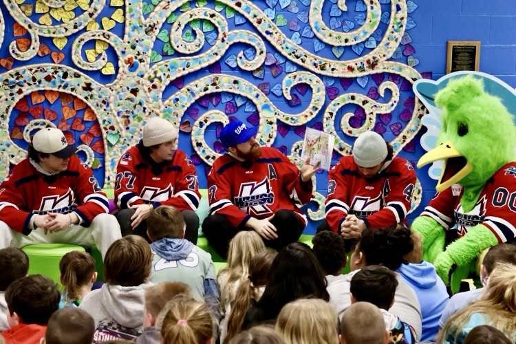 picture of k-wings hockey players reading to Gilkey students 