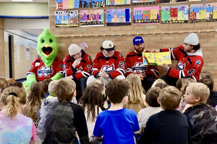 picture of k-wings hockey players reading to Gilkey students 