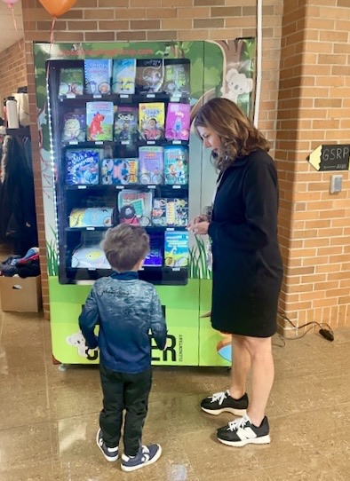 picture of cooper principal with a student at a book vending machine
