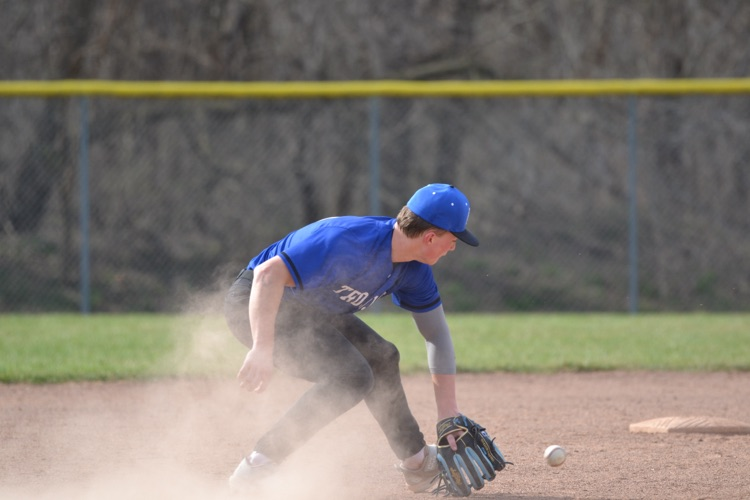 varsity baseball player catching a grounder 