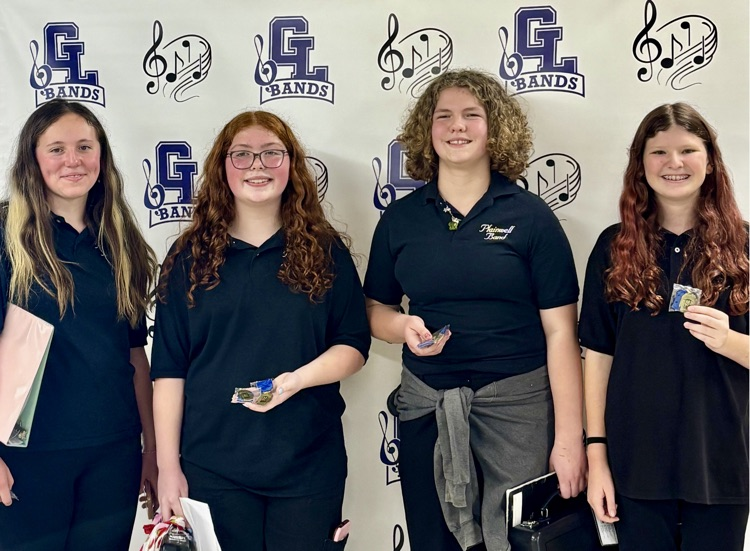 picture of four band students from the middle school holding medals from a festival competition 