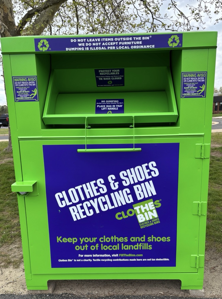 picture of green clothes & shoes recycling bin that is outside the middle school 