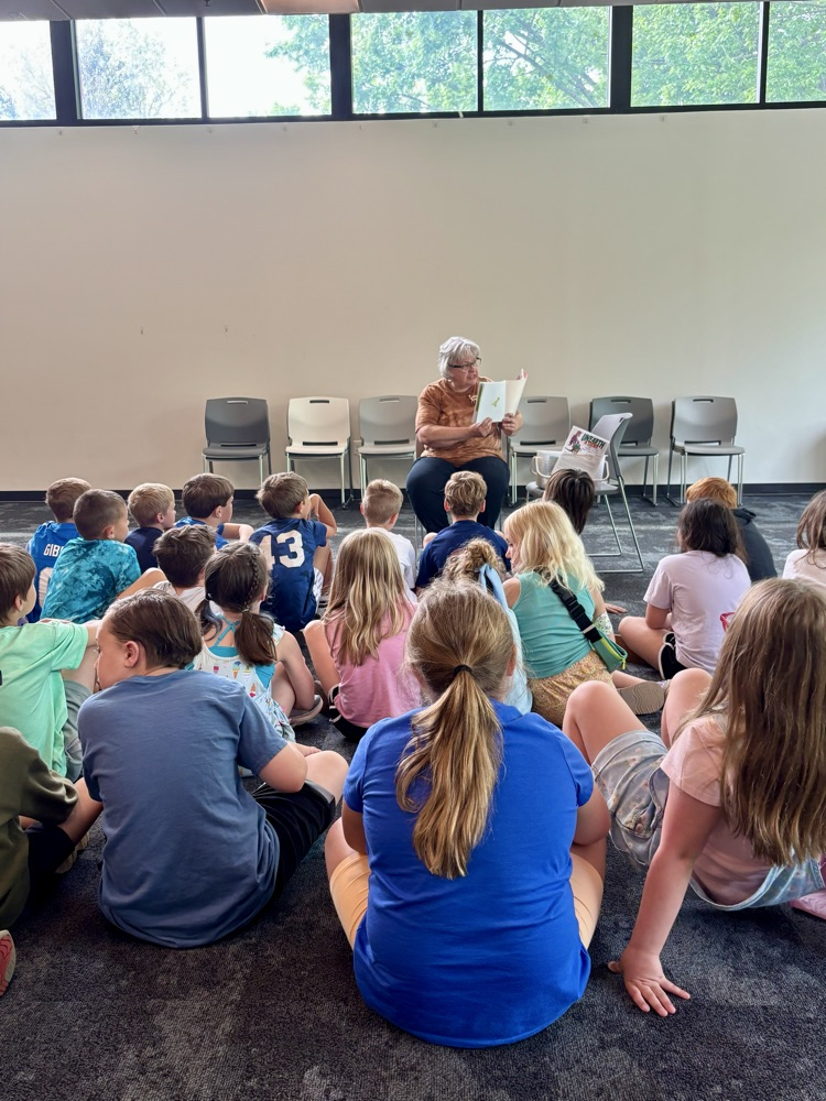 picture of group of students at the ransom district library listening to a librarian read to them