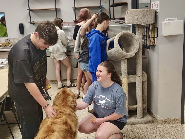 picture of two students petting a dog on a field trip to the Allegan tech center 