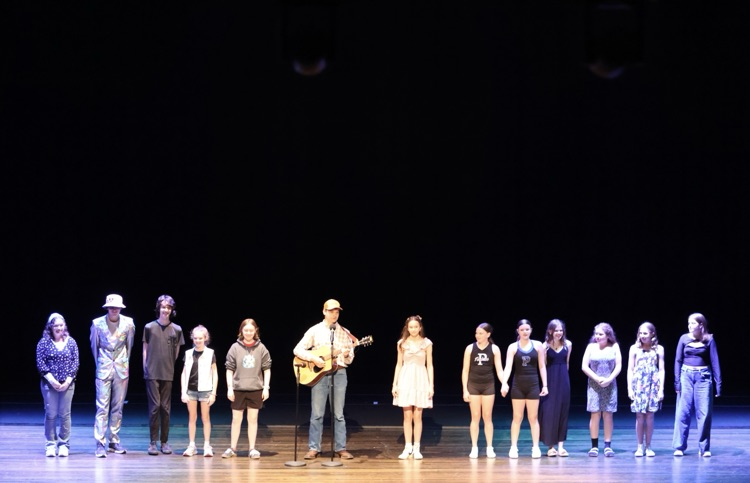picture of 13 students on stage at the performing arts center 