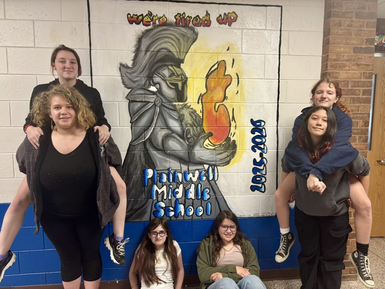 picture of six middle school students standing in front of their new painted mural of a Trojan 