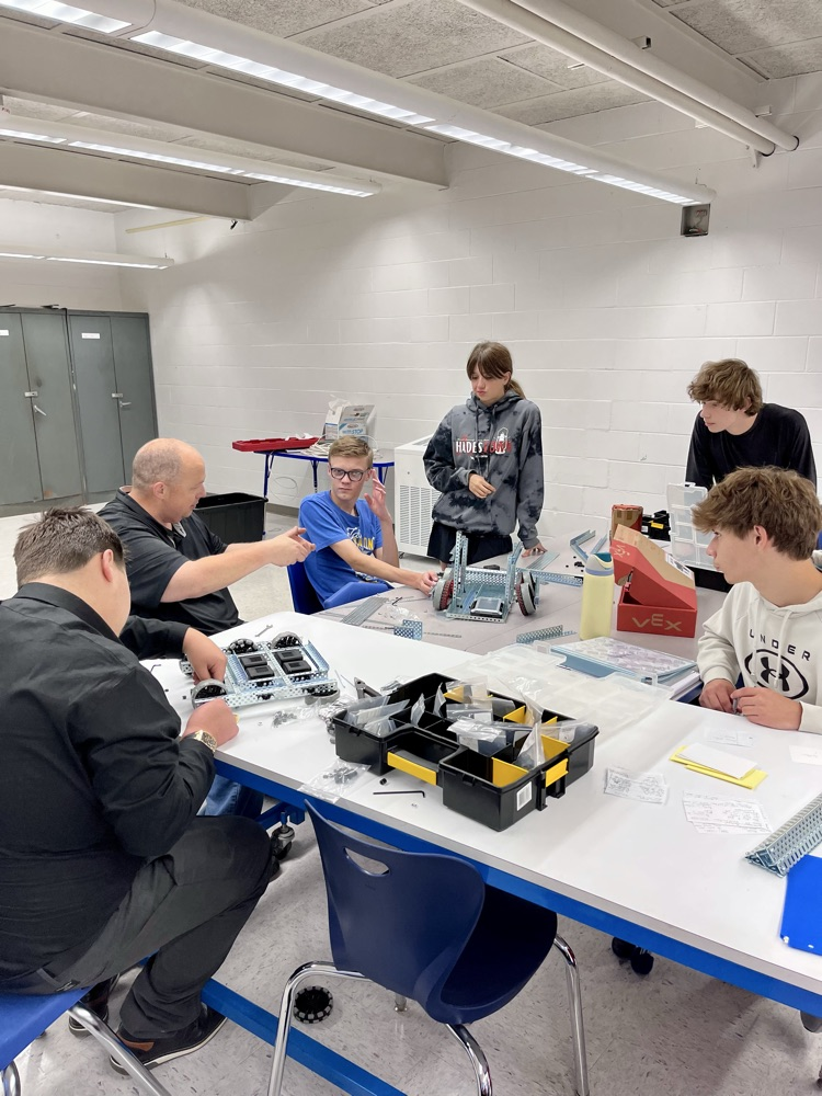 picture of phs teacher working with a group of students in a robotics class
