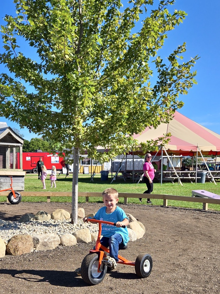 picture of a young 5 student playing at the apple orchard