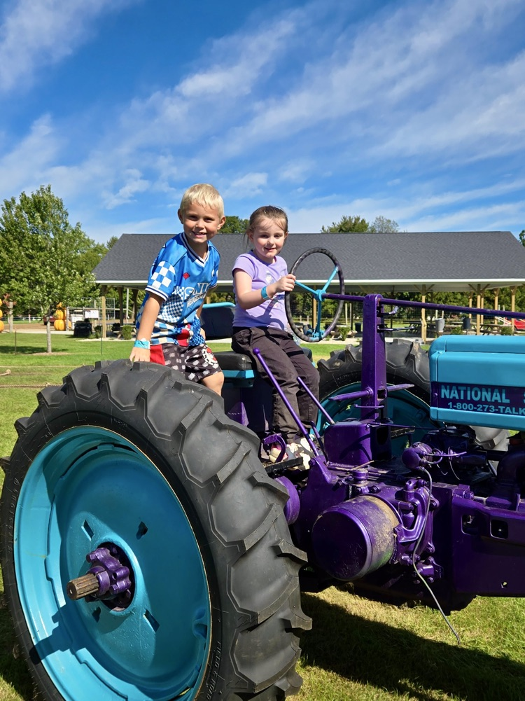 picture of young 5 students on a tractor at the apple orchard