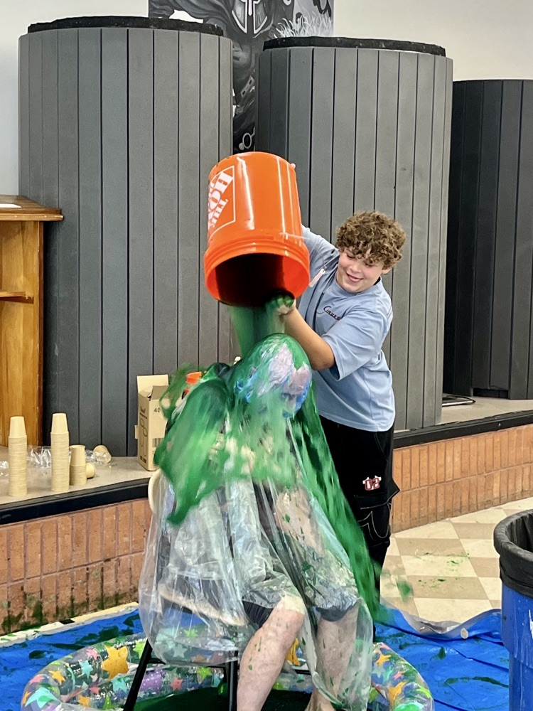 picture of a student dumping a bucket of slime on a teacher