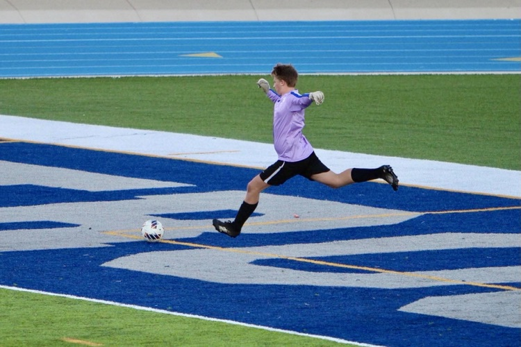 picture of a phs varsity soccer player kicking the ball during a match