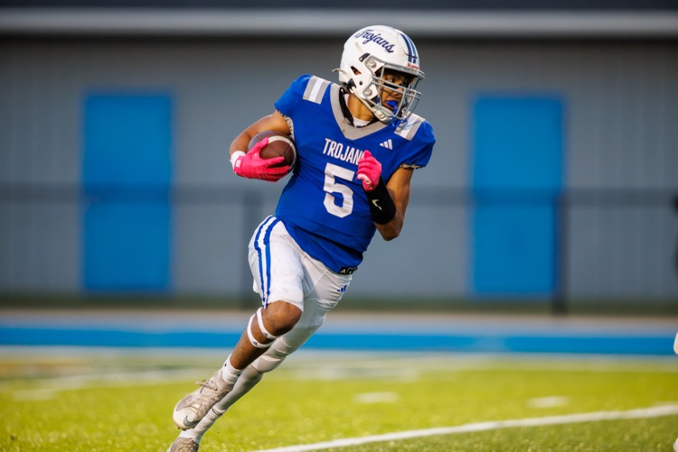 picture of football player running the ball in the homecoming football game