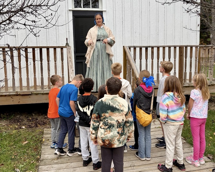 picture of group of students listening to a speaker during a field trip
