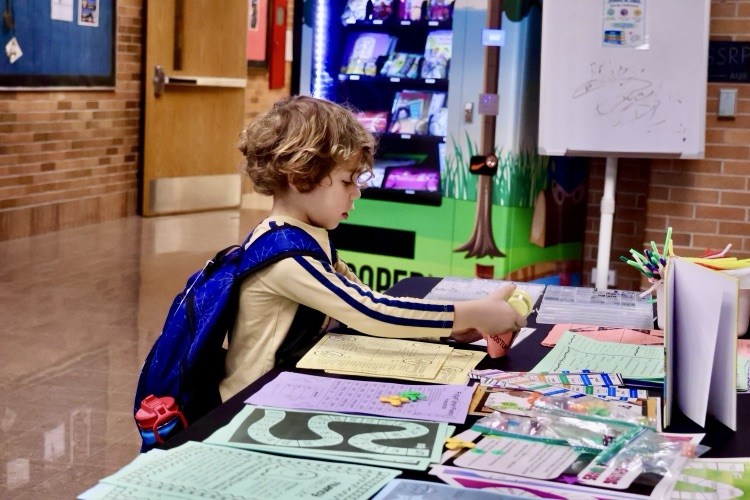 picture of students looking at a table of activities at literacy night event