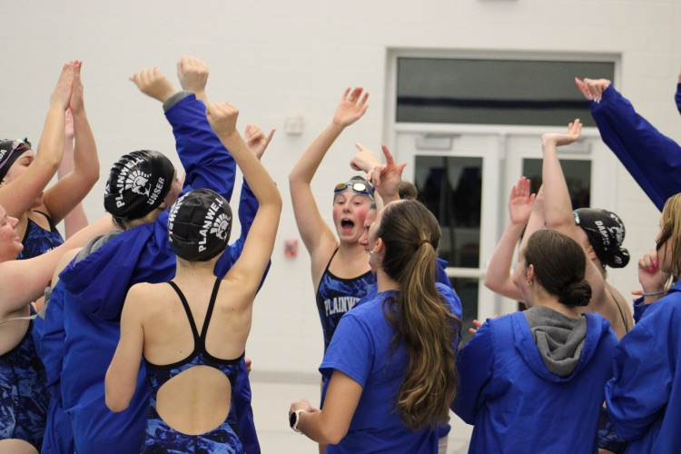 picture of girls swim and dive team cheering during a meet